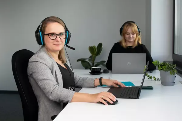 To kundeservicemedarbejdere arbejder på kontoret