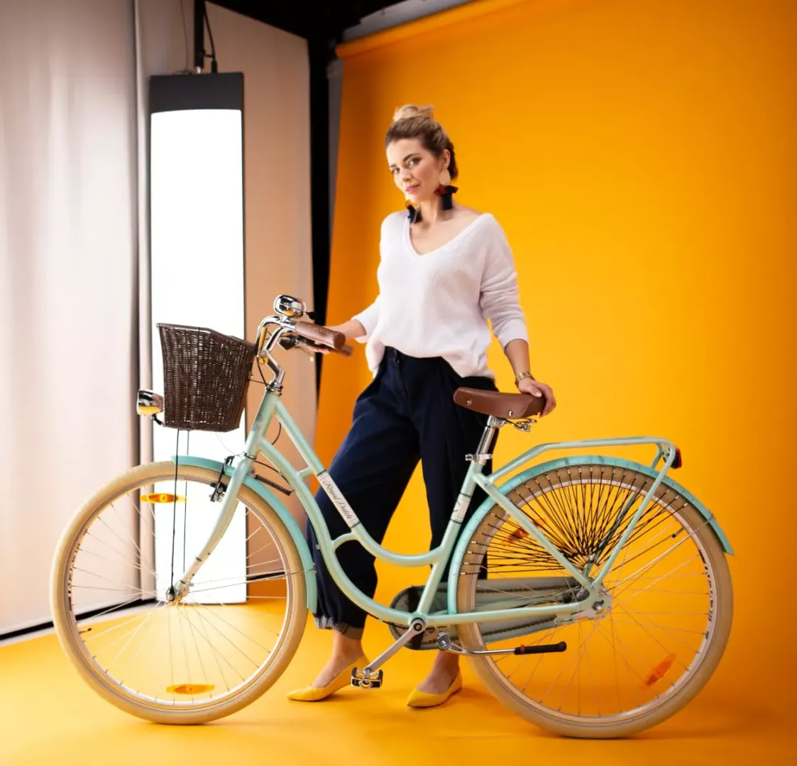Model står ved siden af en cykel i Orbitvus studie til fotografering med live modeller