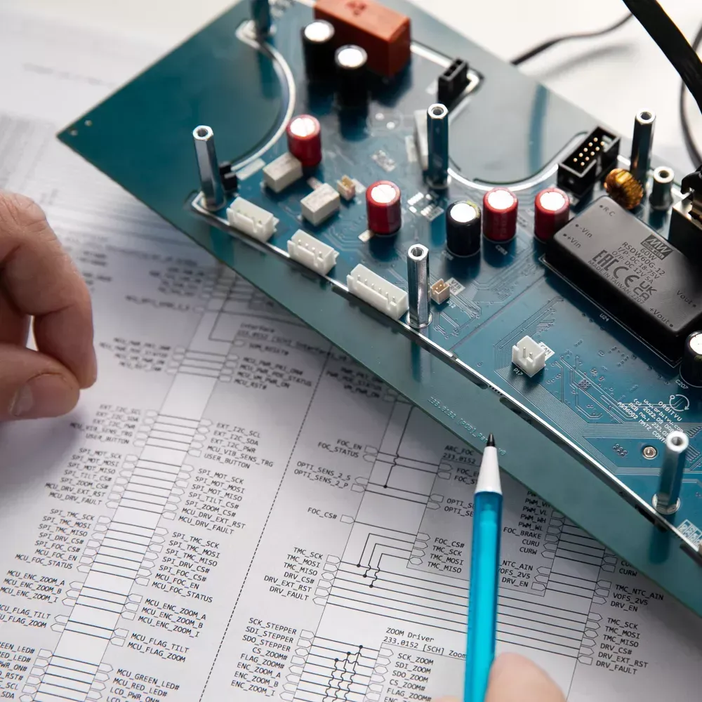 Ingeniør gennemgår elektronisk printkort og diagram