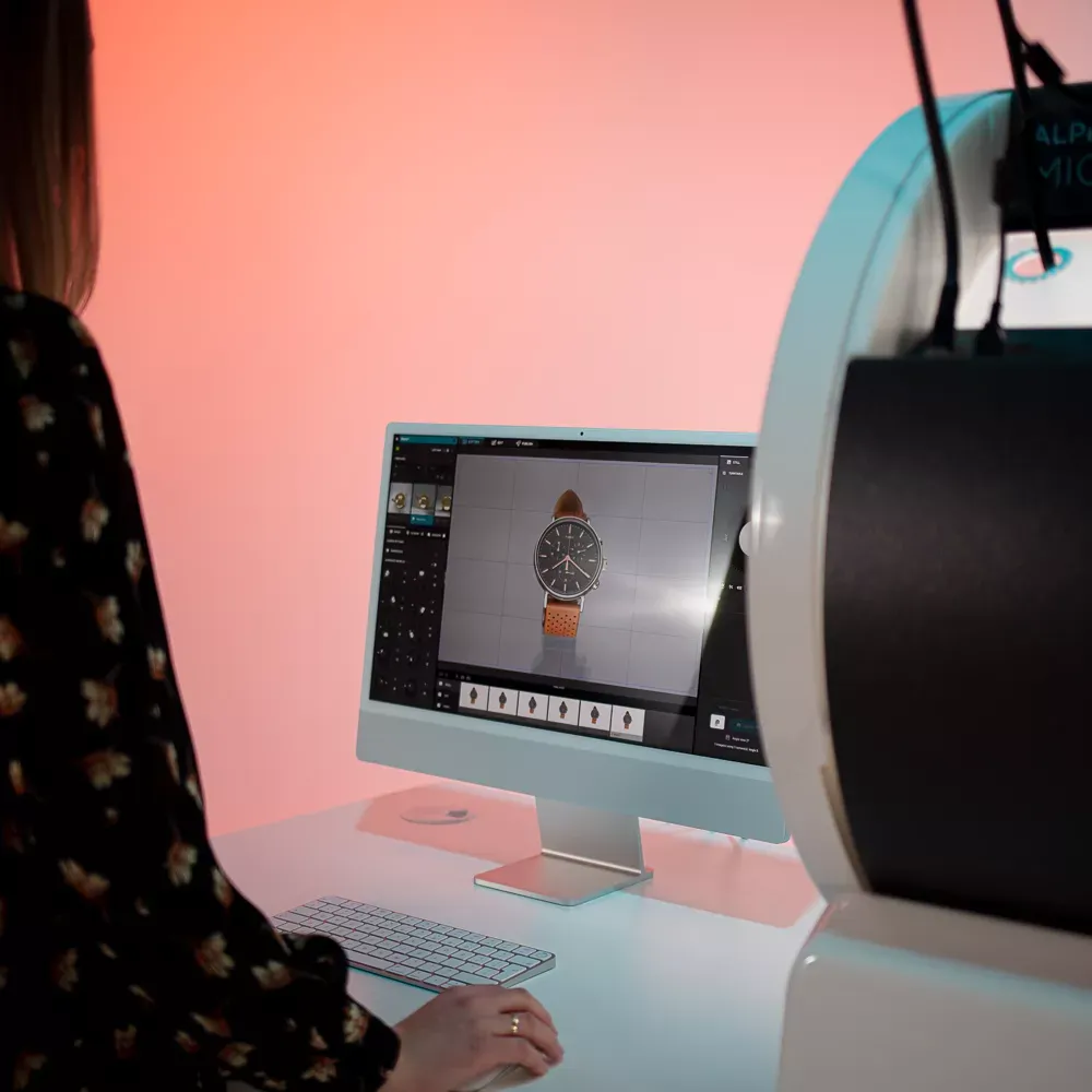 Kvinde, der fotograferer et ur med en softwarebrugerflade på computeren