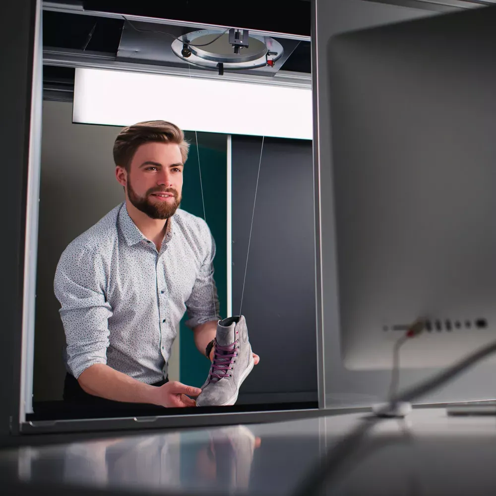 Mand, der forbereder et produkt til professionel skofotografering