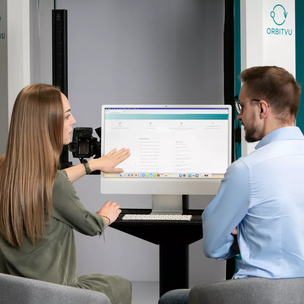 To kolleger gennemgår software på en computerskærm