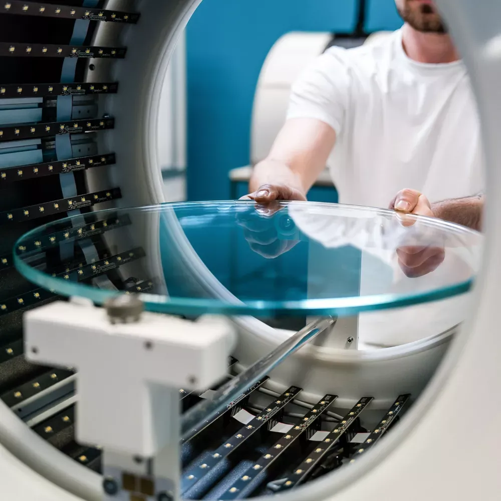 Tekniker placerer glasdrejeskive i automatiseret fotostudie